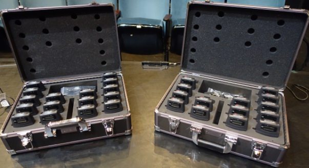 FM receivers in a case against a theatre seating background