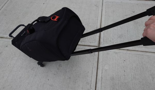a shoulder bag packed with a tour guide system mounted to a trolley